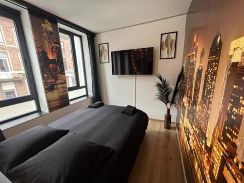 a bedroom with a large bed in a room with windows at Aux trois univers in Verviers