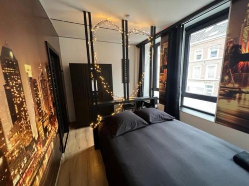 a bedroom with a bed and a large window at Aux trois univers in Verviers