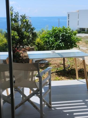 una mesa y sillas en un porche con vistas al océano en Allegro suite, en Tinos