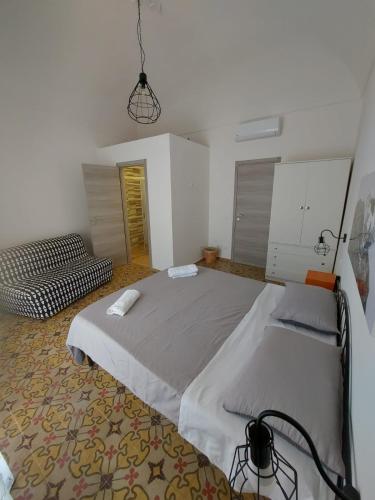 a bedroom with a large bed and a couch at Struttura Le Gemme in Marettimo