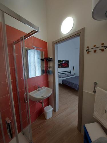 a bathroom with a sink and a mirror and a bedroom at Struttura Le Gemme in Marettimo