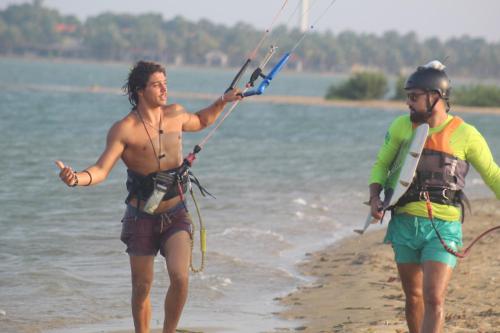 dos personas están de pie en la playa sosteniendo una cometa en Margarita kitesurfing school Sri Lanka en Kalpitiya