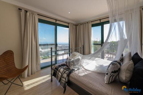 een slaapkamer met een bed en een groot raam bij Villa Monte Leon in Maspalomas