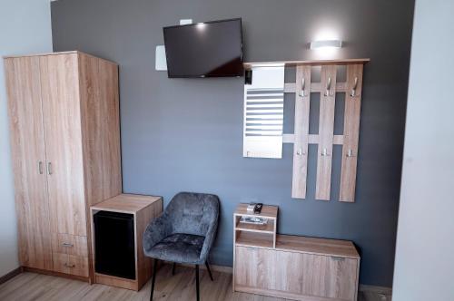 a room with a chair and a cabinet and a tv at Apartman Ružić in Sveti Ivan Žabno