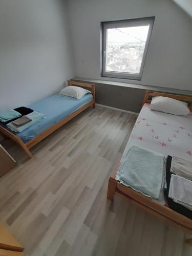 una piccola camera con due letti e una finestra di Skyline apartment a Čapljina