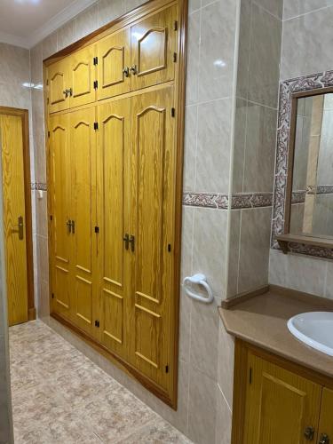 baño con puerta de madera y lavamanos en VILLA LA MOMITA, en Chiclana de la Frontera