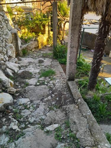 a stone path with trees and a building in the background at Skyline apartment in Čapljina