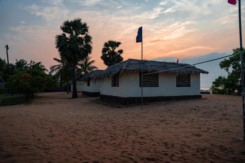a house with a flag on top of it on a beach at MKS - Kite & Wing Foil camp in Kalpitiya