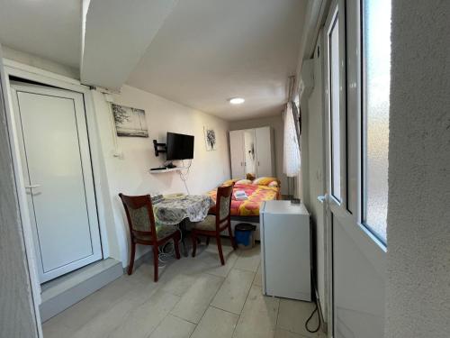 a small room with a table and chairs and a bedroom at Villa Miramare , Dobrota seafront in Kotor