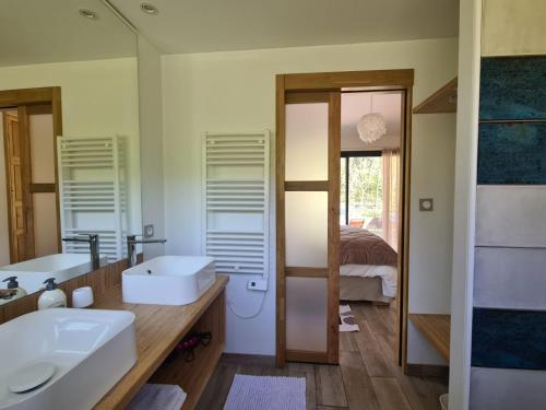 uma casa de banho com 2 lavatórios e um espelho grande em PAUSE NATURE Maison Cosmos avec parking gratuit em Lapeyrouse-Fossat