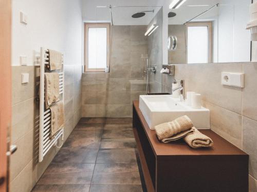 W łazience znajduje się umywalka i lustro. w obiekcie Hotel Turmwies w mieście Tirolo