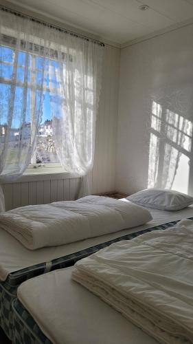 two beds in a bedroom with a window at Haramsøy Holiday Apartment- Island Life North in Haram
