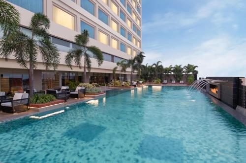 a swimming pool in front of a building at Crowne Plaza New Delhi Mayur Vihar Noida, an IHG Hotel in New Delhi
