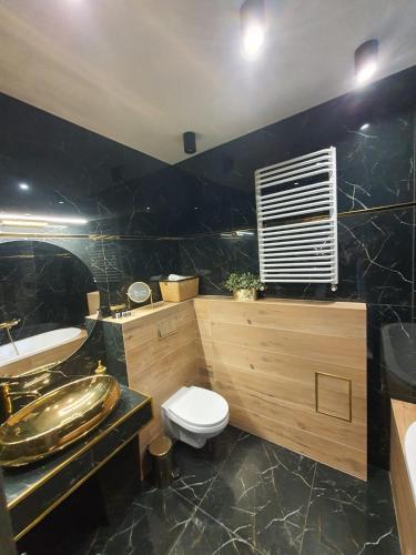 a bathroom with a toilet and a sink and a tub at Apartament Dubaj in Gliwice