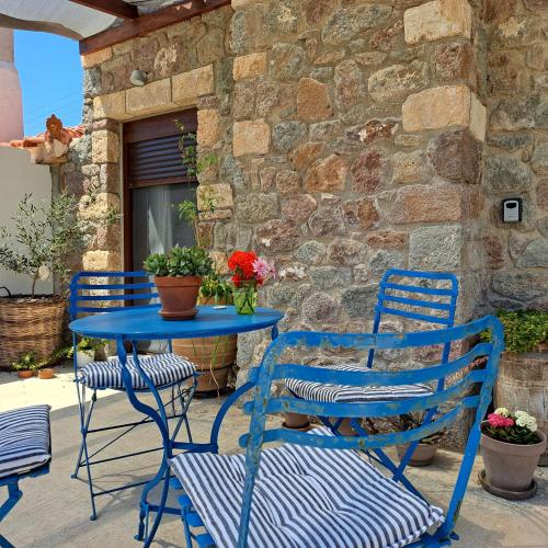 2 sillas azules y una mesa en el patio en BaSiLiKoS, en Perdika