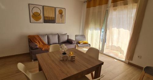 sala de estar con mesa de madera y sofá en LuengiHouse - Espectacular apartamento con piscina, en Lloret de Mar