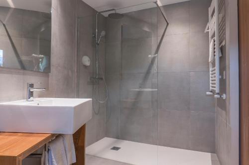 a bathroom with a sink and a shower at Hotel Cardós in Ribera de Cardós