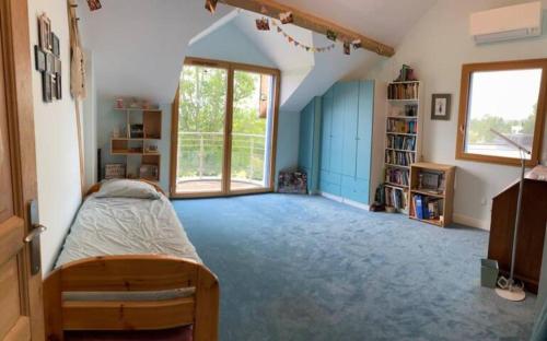 ein Schlafzimmer mit einem Bett und einem großen Fenster in der Unterkunft Jardin face aux Pyrénées in Gelos