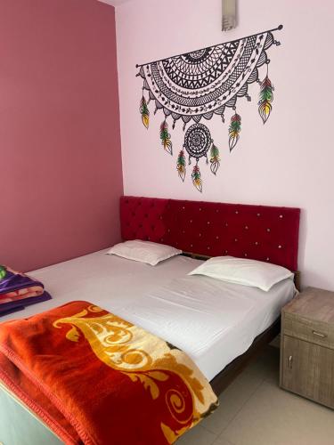 a bedroom with a bed with a red headboard at Banaras Guest House in Varanasi