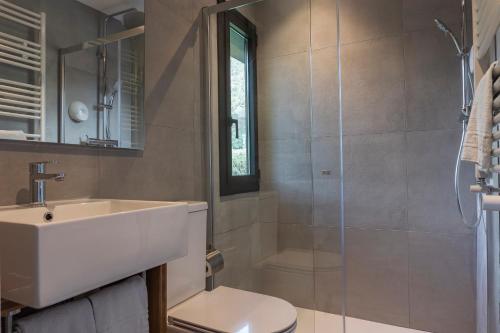a bathroom with a sink and a toilet and a shower at Hotel Cardós in Ribera de Cardós