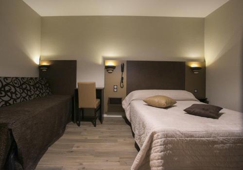 a hotel room with two beds and a couch at Hotel du Col d'Osquich in Musculdy