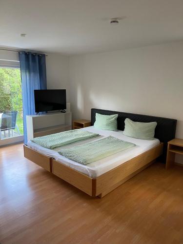 a bedroom with a large bed with a tv on it at Apartment FIVE - EP Ticket Garantie in Rust