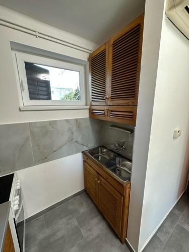 a small kitchen with a sink and a window at Hangulatos Balaton parti nyaraló in Révfülöp