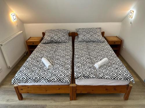 a bedroom with a bed with a black and white comforter at Hangulatos Balaton parti nyaraló in Révfülöp