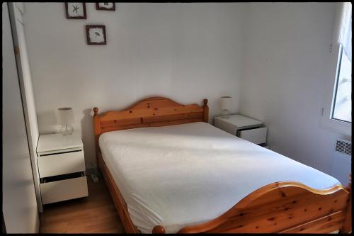 a bedroom with a wooden bed and two night stands at Le plongeoir in Saint-Trojan-les-Bains