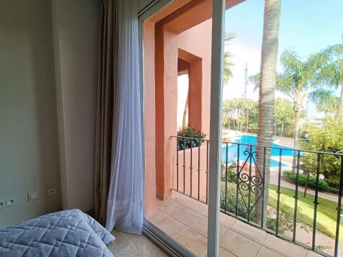 a bedroom with a balcony with a view of a pool at Oasis 3 bedroom Marbella Golden Mile in Marbella