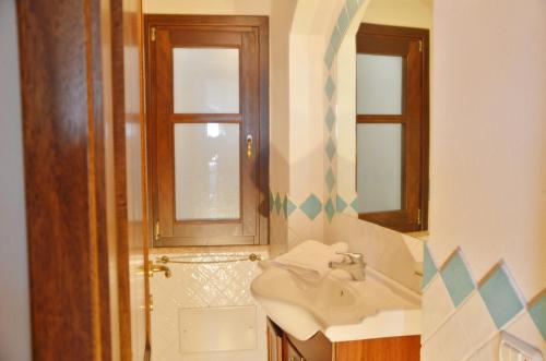 een badkamer met een wastafel en een spiegel bij Mandorlo 5 in Santa Maria Navarrese