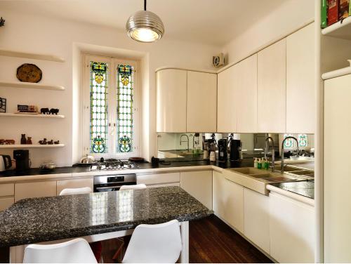 a kitchen with white cabinets and a black counter top at Villa Ella in Luxury Resort in Gardone Riviera