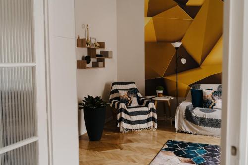 a living room with a yellow accent wall at FAND Center Apartman Luxury in Szeged