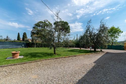 a garden with trees and a gravel road at Ovaiola in Civitella in Val di Chiana