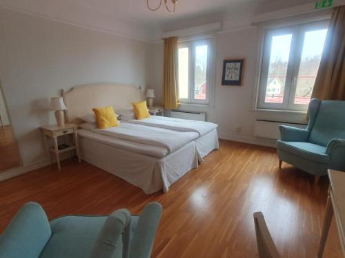 a bedroom with a bed and a blue chair at Möckelsnäs Herrgård in Diö