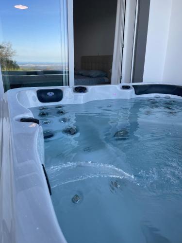 a jacuzzi tub in a bathroom with a window at Luar do Algarve in Monchique