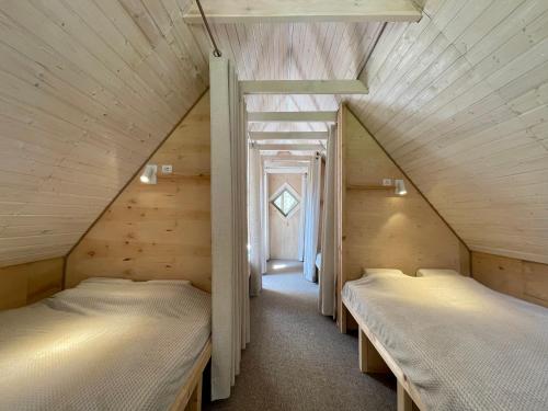 2 bedden in een zolderkamer met houten wanden bij Holiday homestead Camp of Forest Souls 