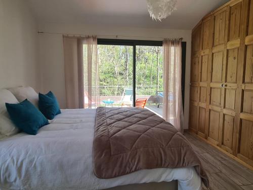 a bedroom with a large bed and a large window at PAUSE NATURE Maison Cosmos avec parking gratuit in Lapeyrouse-Fossat