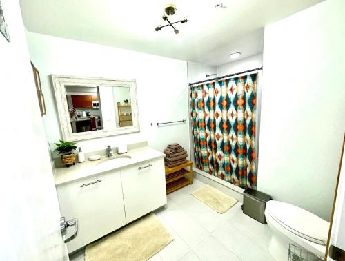uma casa de banho com um lavatório, um WC e um espelho. em Platinum 1BD 1BTH at Midblock em Miami