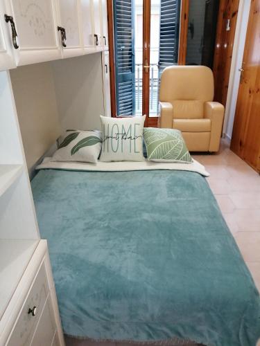 a large bed in a room with a chair at casa vacanza con balcone in Laterza