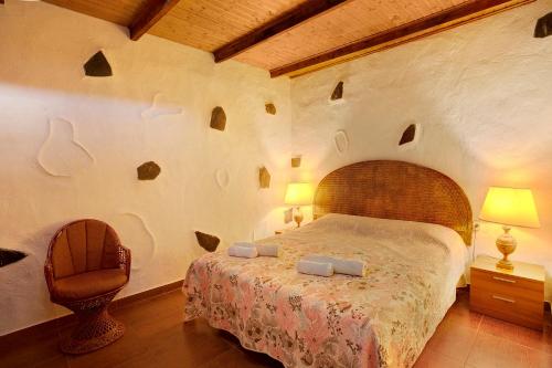 a bedroom with a large bed and a chair at Casa Rural Jovial in Ingenio