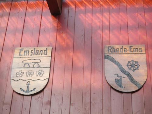 two signs on the side of a wooden wall at Landhotel Vosse-Schepers in Rhede