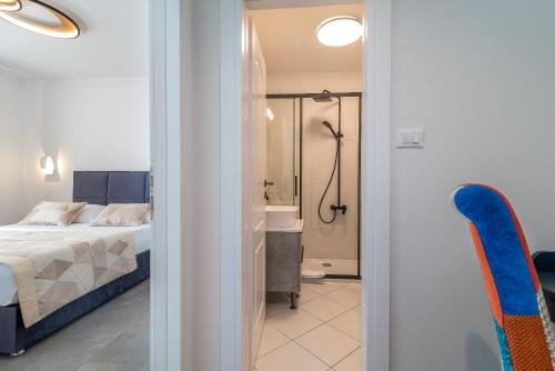 ein Schlafzimmer mit einem Bett und ein Badezimmer mit einer Dusche in der Unterkunft Apartments Liam in Trogir