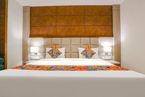 a bedroom with a large white bed with colorful pillows at FabHotel Hexa Chhatarpur in New Delhi