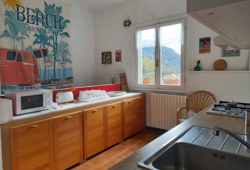 a kitchen with a sink and a microwave in it at Villa ai Sugheri in Deiva Marina