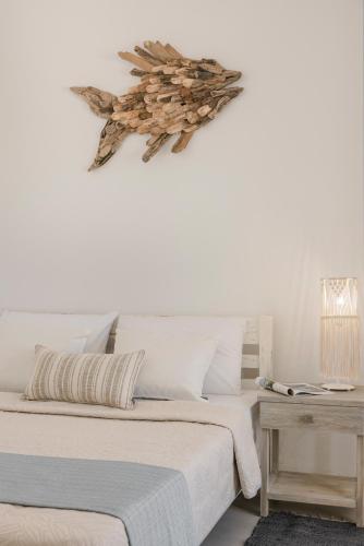 a white bedroom with two beds and a table at Pebble Summer House in Kampos Paros