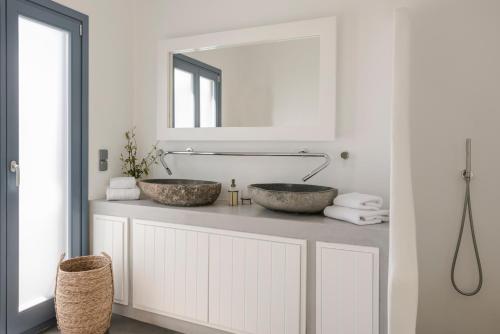 un bagno con due lavandini su un bancone con specchio di Pebble Summer House a Kampos Paros