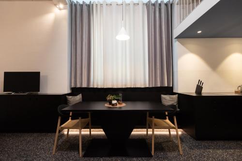 uma sala de jantar com uma mesa preta e cadeiras em Pepper Lounge & Suite em Bolzano