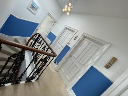 two doors in a stairwell with blue walls at Sandy Toes - awesome beach view and access in Ventnor