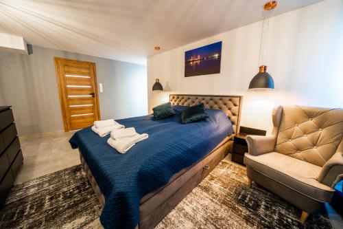 1 dormitorio con 1 cama azul y 1 silla en Apartament P&B en Rybnik